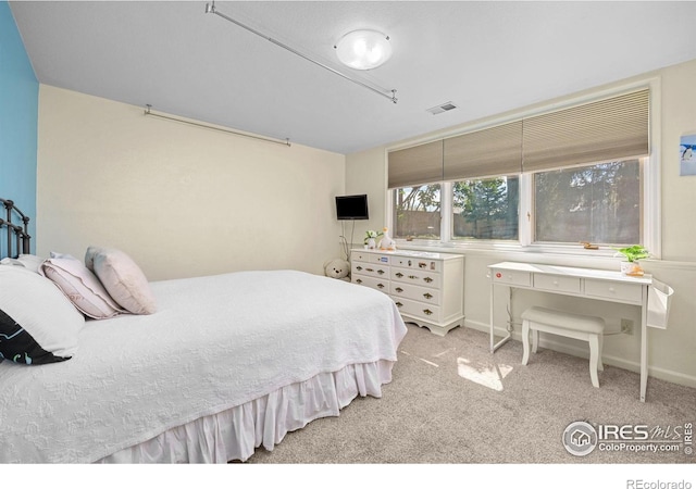 carpeted bedroom featuring baseboards and visible vents
