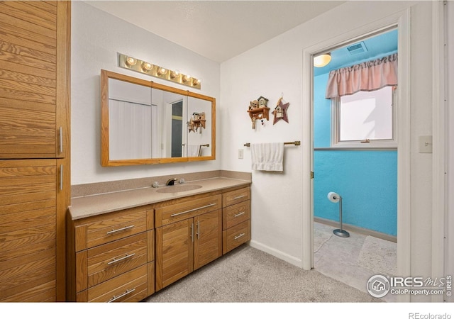 bathroom with vanity, baseboards, and visible vents