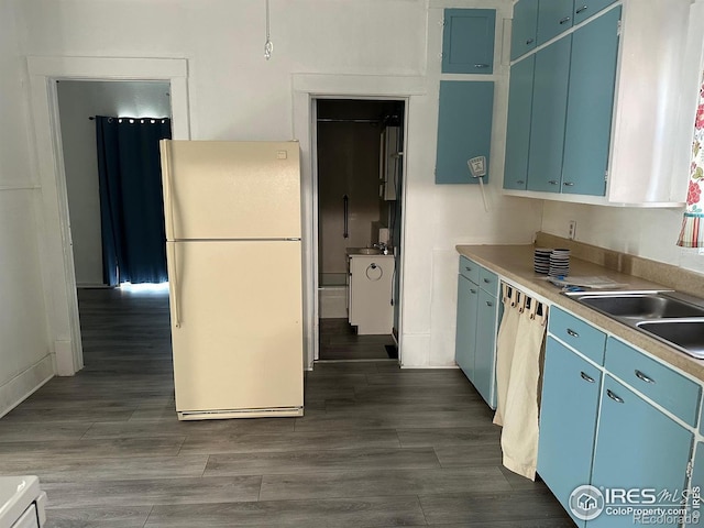 109 E 5th St, Julesburg, CO 80737 - kitchen featuring freestanding refrigerator, dishwasher, blue cabinets, light countertops, and dark wood-style floors