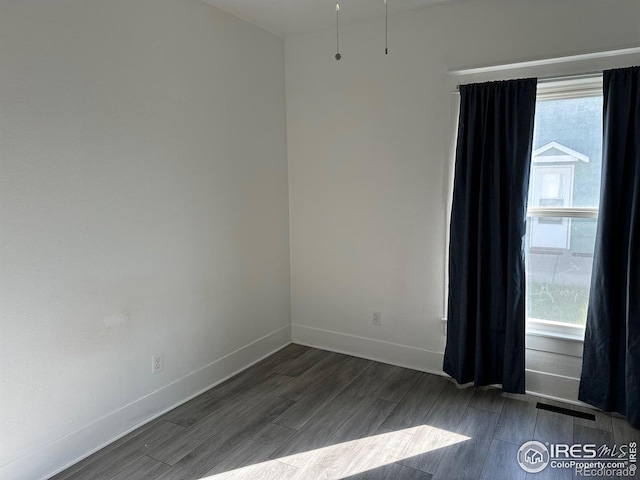 109 E 5th St, Julesburg, CO 80737 - spare room featuring baseboards, visible vents, and dark wood-type flooring