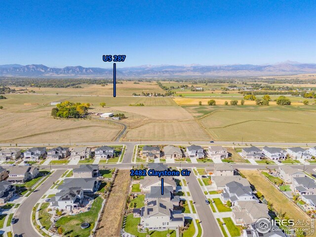 aerial view of property and surrounding area with a mountain backdrop and nearby suburban area