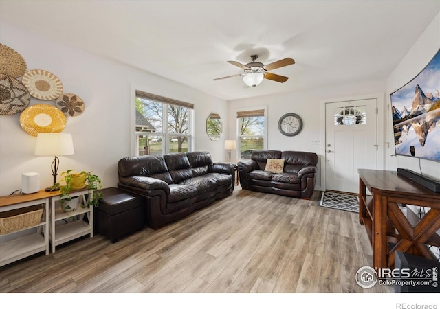 living area featuring light wood-type flooring and a ceiling fan
