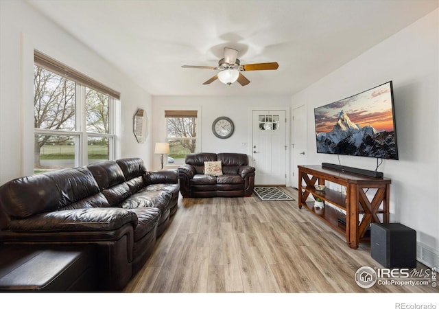 living area featuring light wood-type flooring and a ceiling fan