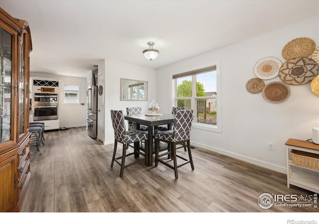 dining space with wood finished floors and baseboards