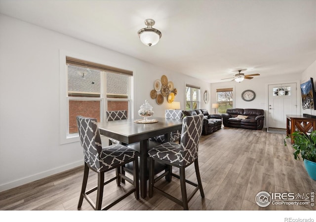 dining room with ceiling fan, light wood-style flooring, and baseboards