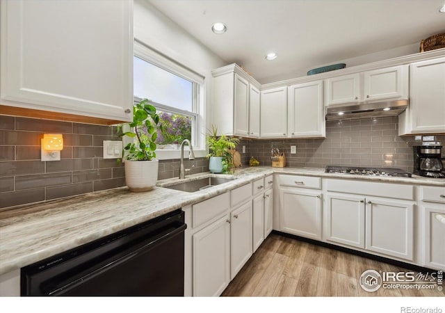 kitchen featuring a sink, stainless steel gas cooktop, dishwasher, under cabinet range hood, and white cabinets