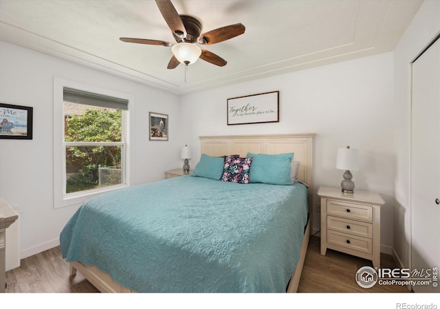 bedroom with ceiling fan, baseboards, and wood finished floors