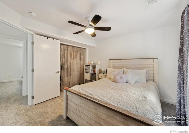 carpeted bedroom featuring a closet, baseboards, and ceiling fan