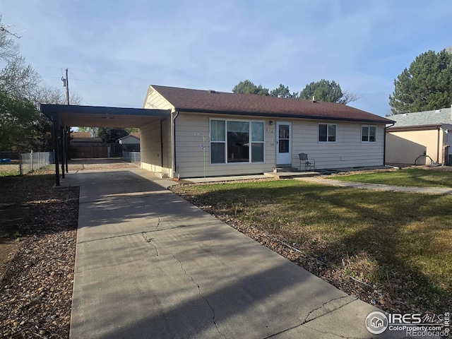 ranch-style house with a front yard, an attached carport, driveway, and fence