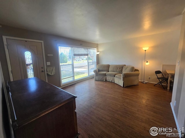 living room featuring baseboards and dark wood-style floors