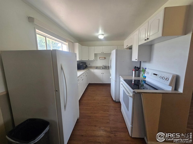 kitchen with white cabinets, light countertops, dark wood-style flooring, and white appliances