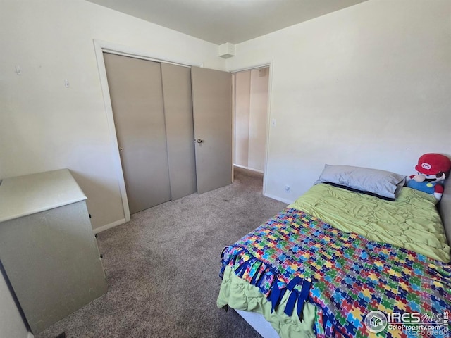 bedroom featuring baseboards, a closet, and carpet