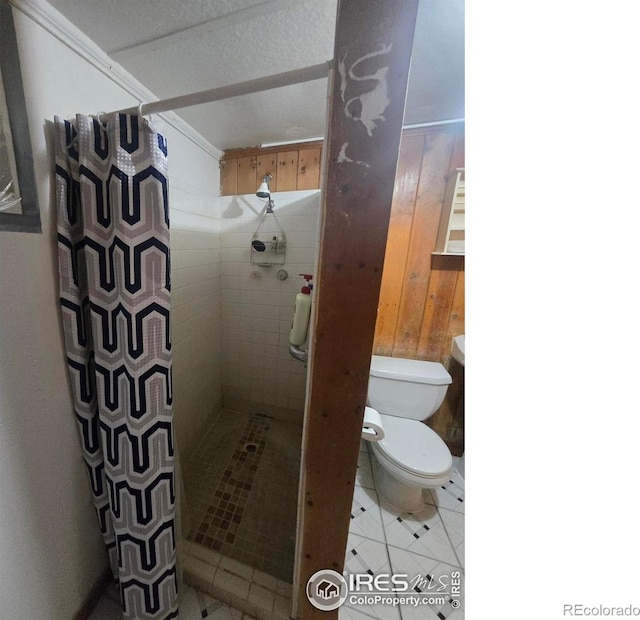 full bathroom featuring tile patterned flooring, toilet, and a shower stall