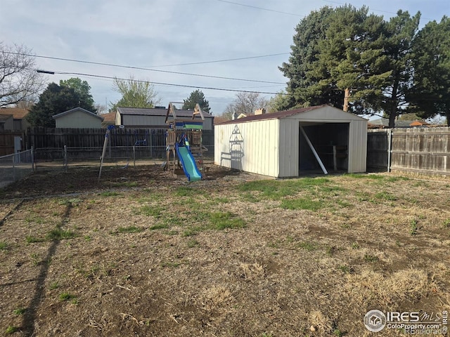 view of shed featuring a fenced backyard and a playground