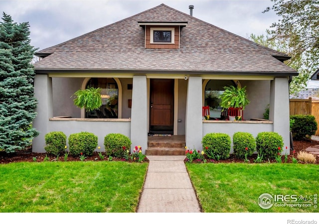 bungalow featuring a shingled roof, a porch, and a front yard