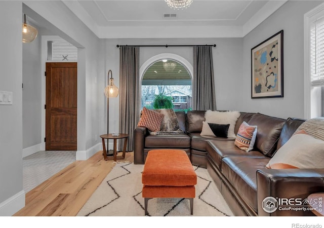 living area with visible vents, wood finished floors, and baseboards