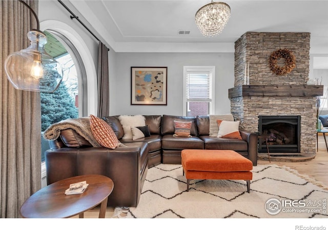 living room with a healthy amount of sunlight, a notable chandelier, visible vents, and wood finished floors