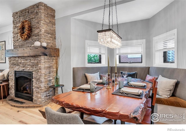 dining room featuring a fireplace, a chandelier, and wood finished floors