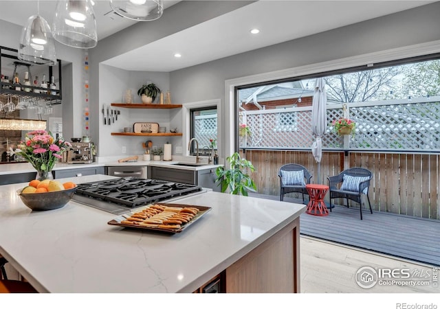 kitchen featuring a sink, open shelves, light stone countertops, gas cooktop, and recessed lighting