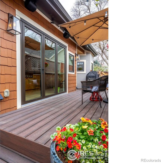 wooden terrace featuring a grill and ceiling fan