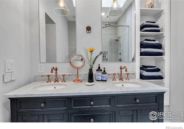 full bath featuring double vanity, a shower stall, and a sink