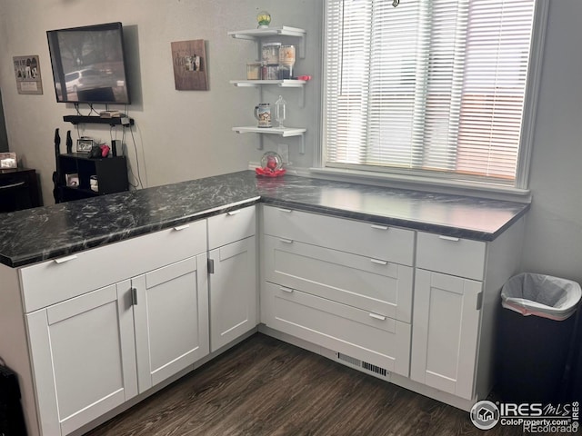 618 Melody Ln, Sterling, CO 80751 - kitchen featuring a peninsula, visible vents, white cabinets, and dark wood-style floors