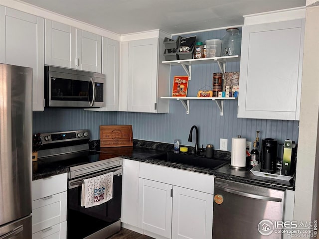 618 Melody Ln, Sterling, CO 80751 - kitchen with a sink, open shelves, dark countertops, white cabinetry, and appliances with stainless steel finishes