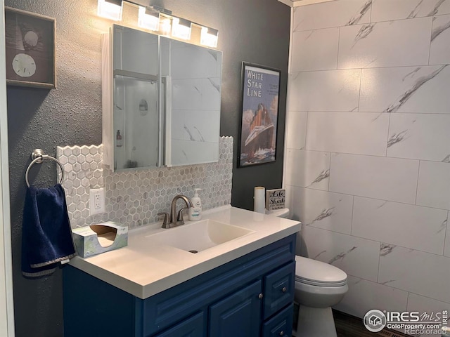618 Melody Ln, Sterling, CO 80751 - bathroom with a stall shower, backsplash, vanity, and toilet