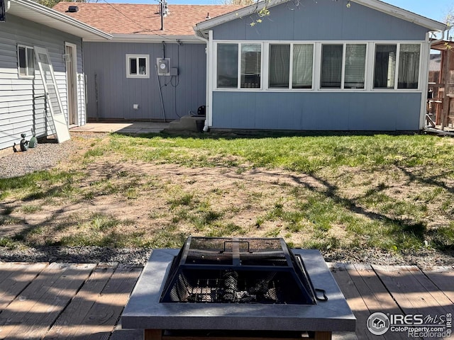 618 Melody Ln, Sterling, CO 80751 - rear view of property featuring a yard, a deck, and a fire pit