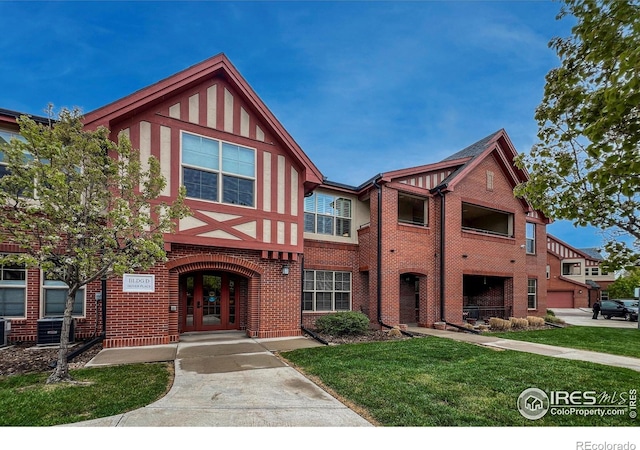 1379 Charles Dr Unit 4, Longmont, CO 80503 - tudor house featuring french doors, brick siding, and a front yard