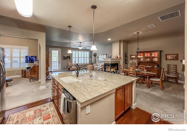 1379 Charles Dr Unit 4, Longmont, CO 80503 - kitchen with a ceiling fan, brown cabinetry, light stone counters, visible vents, and a sink