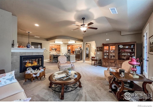 1379 Charles Dr Unit 4, Longmont, CO 80503 - living area featuring a tile fireplace, a ceiling fan, visible vents, light carpet, and lofted ceiling