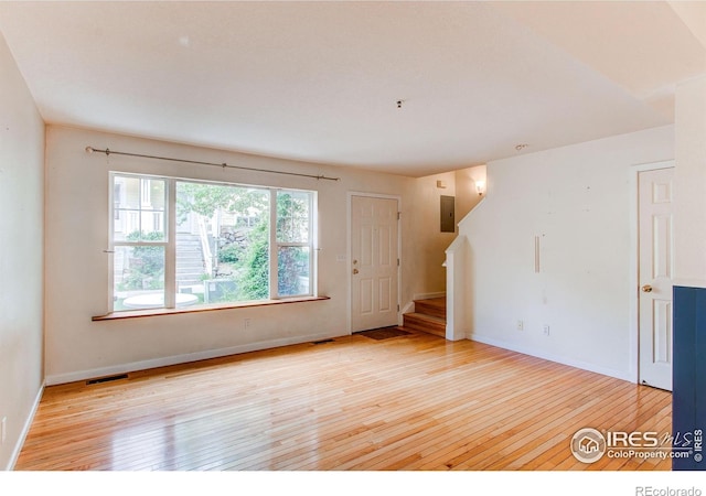 3840 Colorado Ave Unit D, Boulder, CO 80303 - unfurnished living room featuring visible vents, baseboards, hardwood / wood-style floors, and stairs