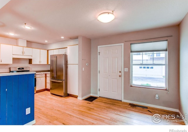 3840 Colorado Ave Unit D, Boulder, CO 80303 - kitchen featuring freestanding refrigerator, under cabinet range hood, white cabinetry, light wood-style floors, and light countertops