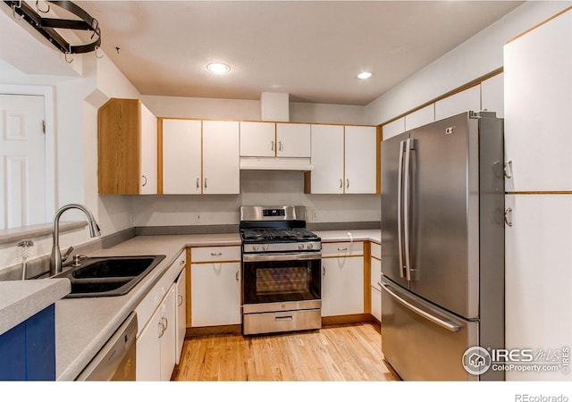 3840 Colorado Ave Unit D, Boulder, CO 80303 - kitchen featuring a sink, under cabinet range hood, light wood finished floors, light countertops, and appliances with stainless steel finishes