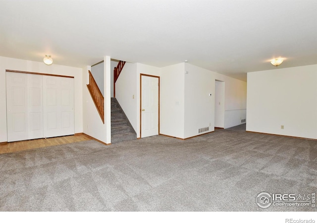 interior space with stairway, baseboards, and carpet floors