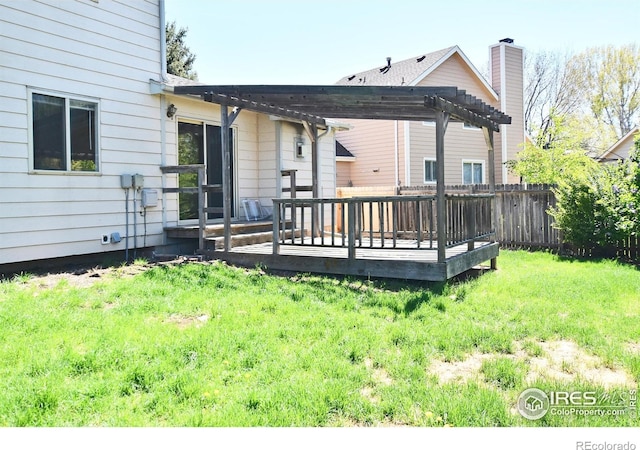 back of house featuring a lawn, a wooden deck, a pergola, and fence