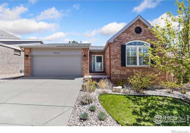 single story home with brick siding, driveway, and a garage