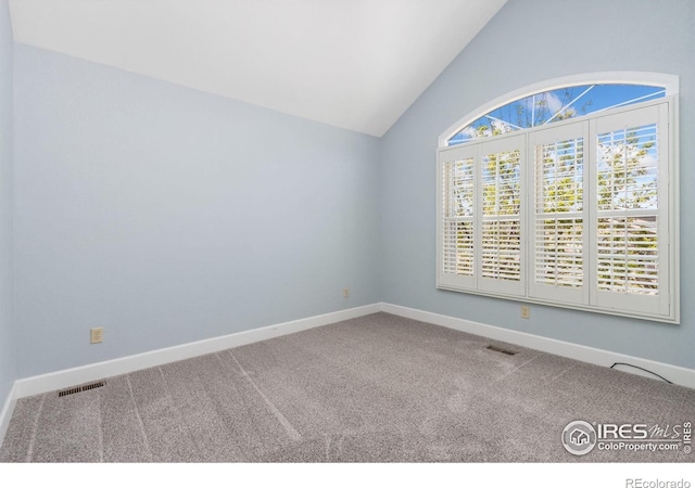 unfurnished room with lofted ceiling, visible vents, and carpet