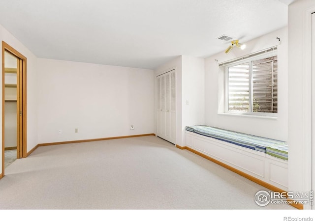 unfurnished bedroom featuring light carpet, baseboards, a closet, and visible vents
