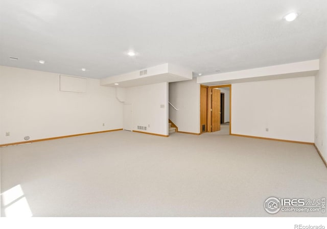 finished basement with recessed lighting, baseboards, visible vents, stairs, and light carpet