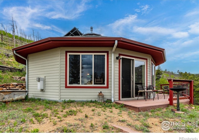 back of house with a deck