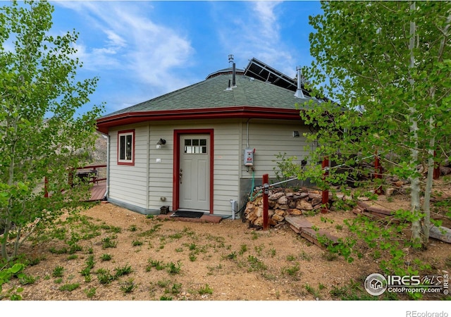 rear view of house with roof with shingles