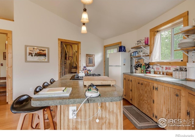 kitchen featuring vaulted ceiling, light wood-style floors, open shelves, and gas water heater