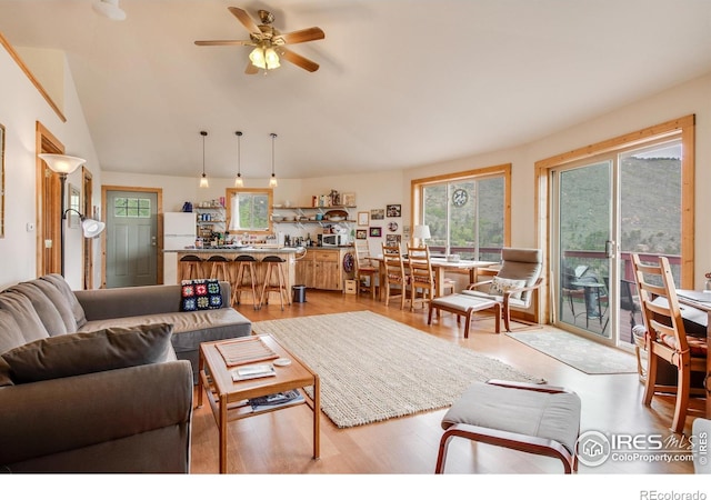 living room with light wood-type flooring, lofted ceiling, and ceiling fan
