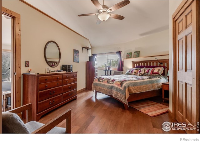 bedroom featuring vaulted ceiling, baseboards, and wood finished floors