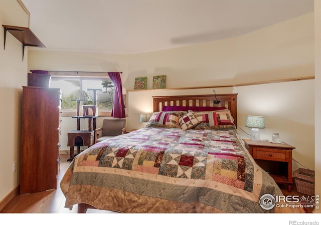bedroom featuring baseboards and wood finished floors