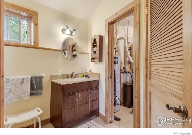 bathroom featuring tile patterned floors, vanity, and water heater