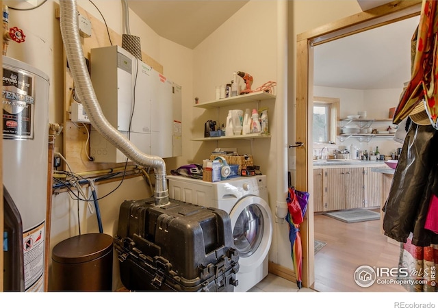 clothes washing area with water heater, light wood-style flooring, laundry area, and washer / clothes dryer