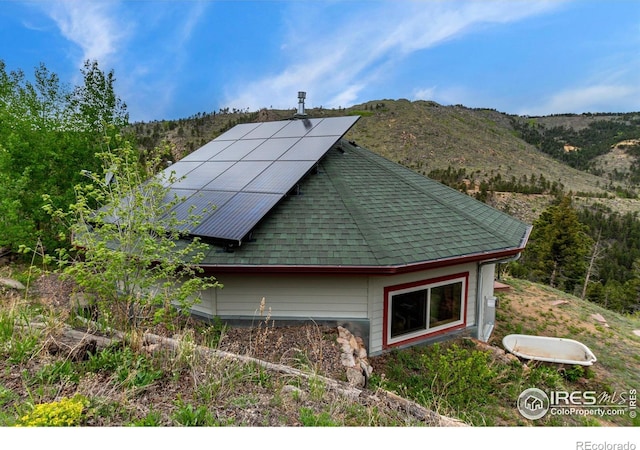 exterior space with a mountain view and solar panels